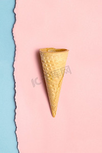 在撕破的墙纸背景下，一个甜蜜的空心饼圆锥体的创意静物。