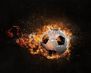 火焰足球摄影照片_球在火中燃烧。足球在黑暗的背景下熊熊燃烧