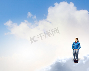 云上的女人摄影照片_天堂里的女人。坐在椅子上的年轻女子坐在高空的云上