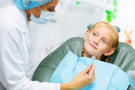 牙齿检查可爱的微笑的女孩在牙医坐在扶手椅