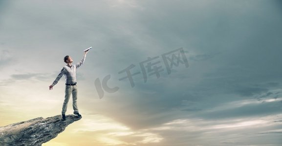 书籍能让你超越其他人。一位年轻英俊的男士随手拿着书