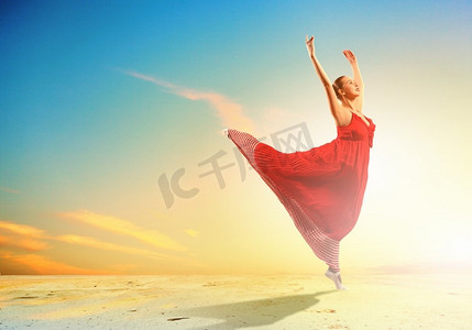 芭蕾舞女演员。日落背景下，芭蕾舞女演员在海岸跳舞的形象