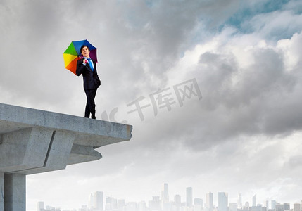 伞边摄影照片_桥上的生意人。打着伞站在桥边的商人形象