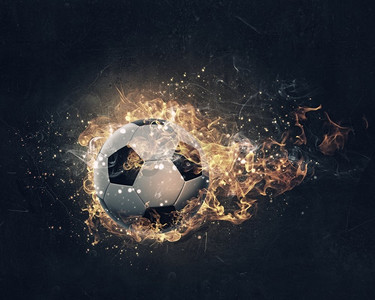球在火中燃烧。足球在黑暗的背景下熊熊燃烧