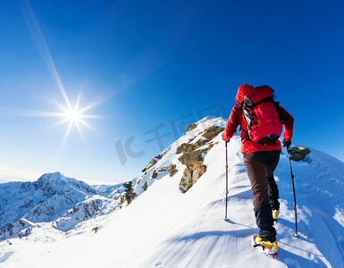 极限冬季运动：登山者在阿尔卑斯山积雪的山顶上。理念：决心、成功、勇敢。