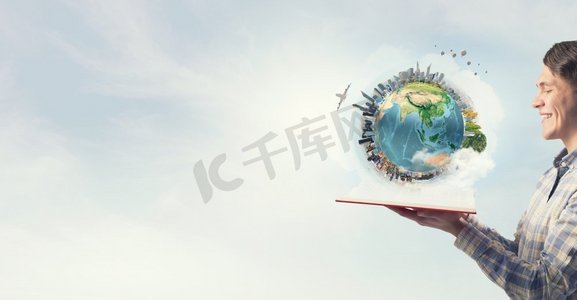 开封旅游摄影照片_探索我们周围的世界。年轻人手里拿着打开的书。这张图片的要素由美国宇航局提供