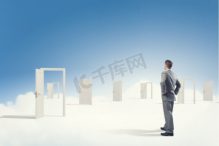 通向新机遇的大门。一位商人站在敞开的大门前做决定