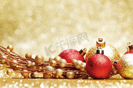 红色金色摄影照片_闪闪发光的金色背景上五颜六色的圣诞装饰品