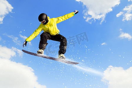 单板滑雪。单板滑雪运动员在晴朗的天空中跳得很高