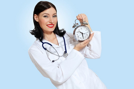 时间治愈摄影照片_带着钟表的年轻女医生。幸福成功的年轻女医生拿着时钟的肖像