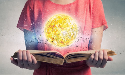 探索太空行星。近距离看女人拿着翻开的书和翻页的太阳星球
