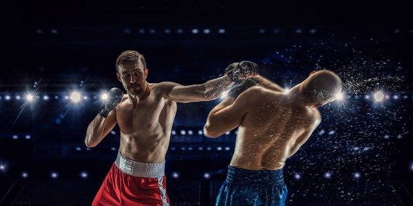 拳击手摄影照片_职业拳击比赛。两名职业拳击手在聚光灯下混杂媒体在竞技场上打架