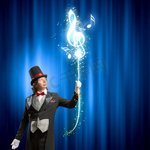 戴帽子的魔术师。男子魔术师在彩色背景下表演魔术的形象