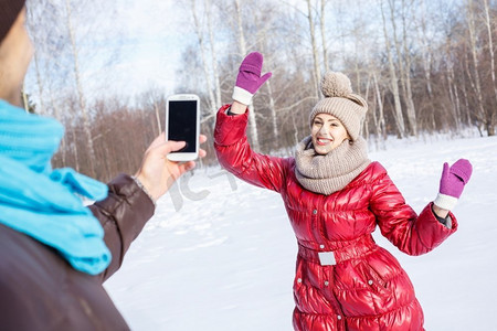 在冬季公园散步年轻人在冬季公园使他的女朋友的照片