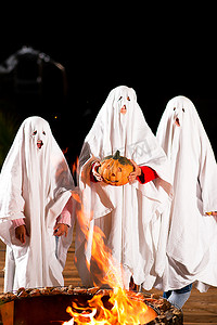三个非常非常可怕的幽灵--孩子们装扮成鬼魂--在万圣节前夕，或者狂欢节，或者在火堆前的化妆舞会上；焦点是南瓜