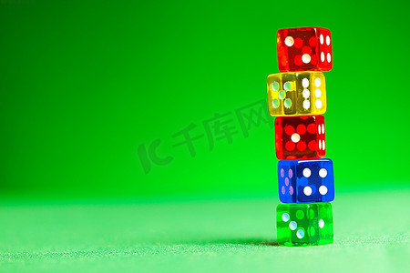 绿色布料上的五颜六色的骰子。