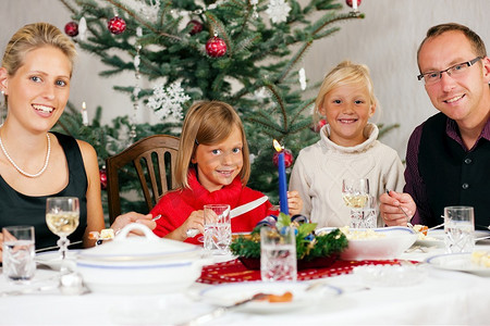 一家人在圣诞树前吃传统的圣诞晚餐