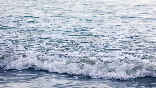 沙滩海水摄影照片_海水浪花流向沙滩