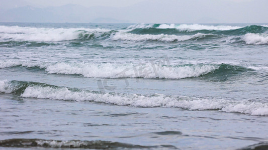 沙滩海浪摄影照片_海水浪花流向沙滩