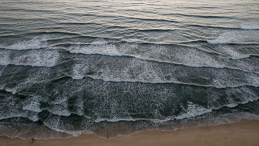 沙滩摄影照片_海水浪花流向沙滩