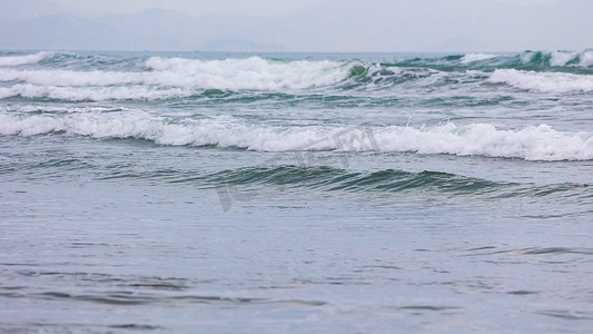 沙滩海水摄影照片_海水浪花流向沙滩