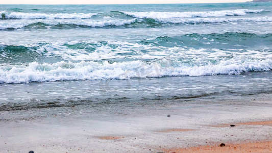 沙滩海水摄影照片_海水浪花流向沙滩