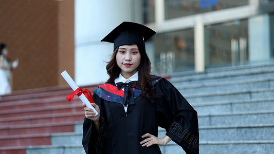 证书荣誉证书摄影照片_手拿毕业证书黑板穿学士服的大学毕业生
