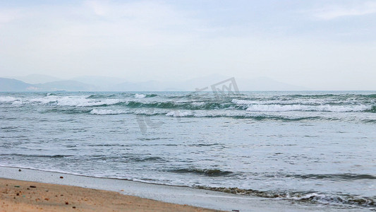 沙滩海浪摄影照片_海水浪花流向沙滩