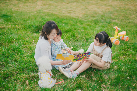 在草坪上看书的母女三人