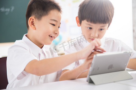 分享小学摄影照片_两个小学生在使用平板电脑