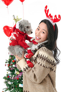 传统狗摄影照片_抱着宠物狗的青年女人过圣诞节