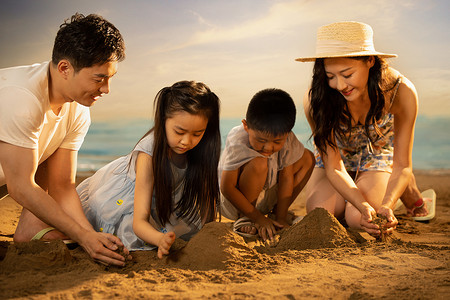 快乐的四口之家在沙滩上玩沙子