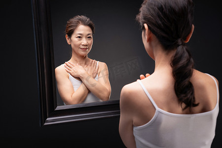 漂亮的中年女性欣赏镜子中的自己