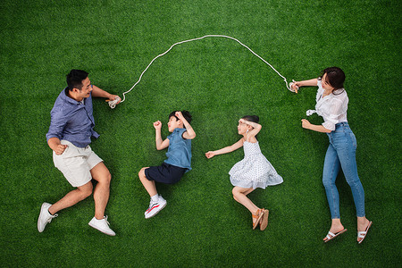 四口人摄影照片_快乐的一家四口在草地上跳绳
