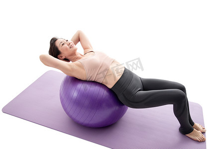 躺在瑜伽球上做瑜伽的中年女性