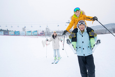 滑雪场内一边滑雪一边玩耍的三口之家