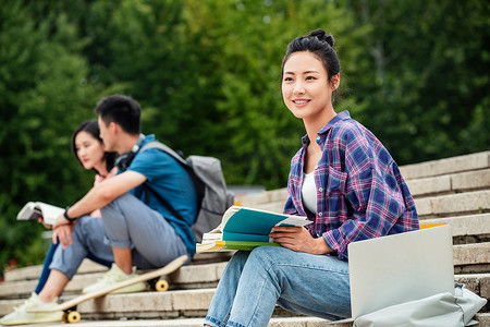 快乐的大学生坐在台阶上学习