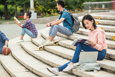 快乐的大学生坐在台阶上学习