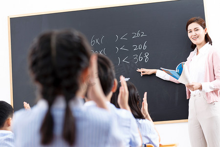 学生不举手摄影照片_女教师和小学生们在教室里