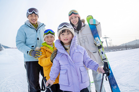 快乐的年轻家庭来滑雪场滑雪玩耍