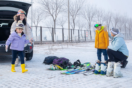 停车场内清点滑雪装备的一家四口