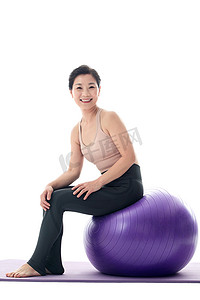 中年女性坐在瑜伽球上休息