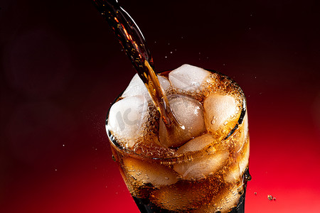 可乐图片摄影照片_可乐倒入装满冰块的杯中