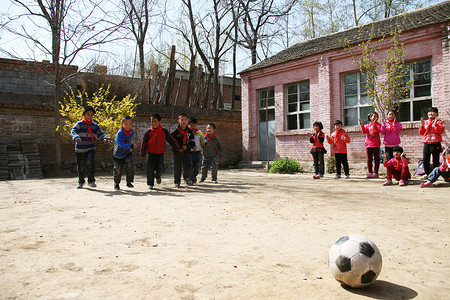 乡村小学生在学校里踢足球