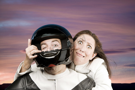 摩托车碰撞摄影照片_男人和害怕的女人骑摩托车