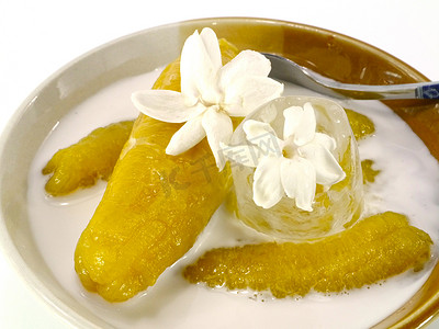水果煮熟摄影照片_用糖浆和椰奶煮熟的香蕉。