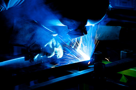 人类在金属行业中带着许多火花进行焊接的工作