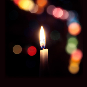 深色背景中蜡烛的火焰，带有彩色散景