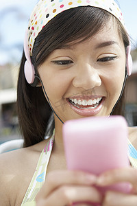 快乐的年轻女人在 MP3 播放器上听音乐
