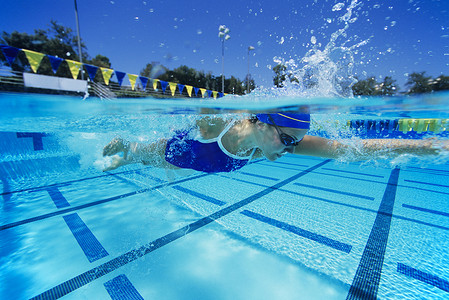 泳池中一名年轻女游泳者的侧视图